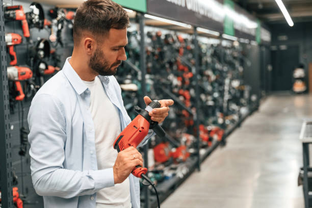 istock Checking the drill. Man is in the hardware shop 2168543526