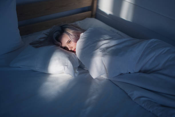 Blonde woman lying on bed.