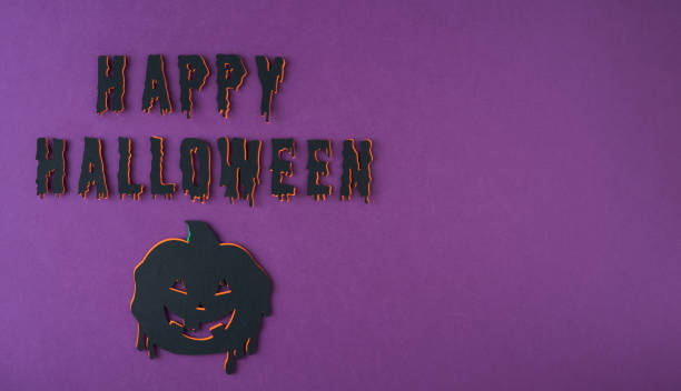 istock A pumpkin with a smiley face and dripping paint on a black background with the words Happy Halloween written in black. made of paper. 2168551012