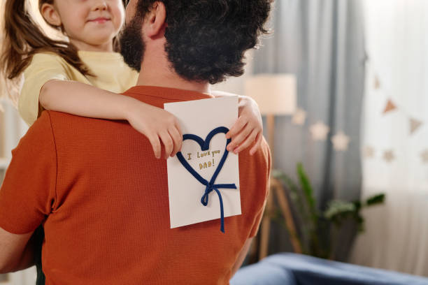 istock Embracing Kid Holding Handmade card for Dad 2168556324
