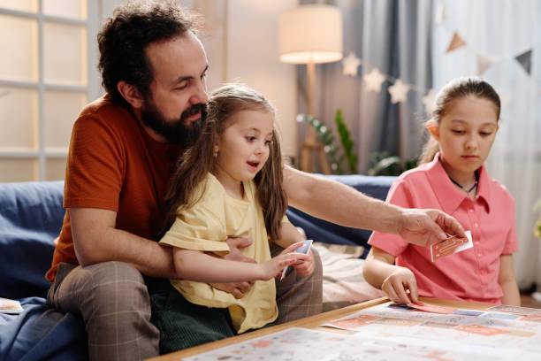 istock Playing Board Game Together in Cozy Living Room 2168556343