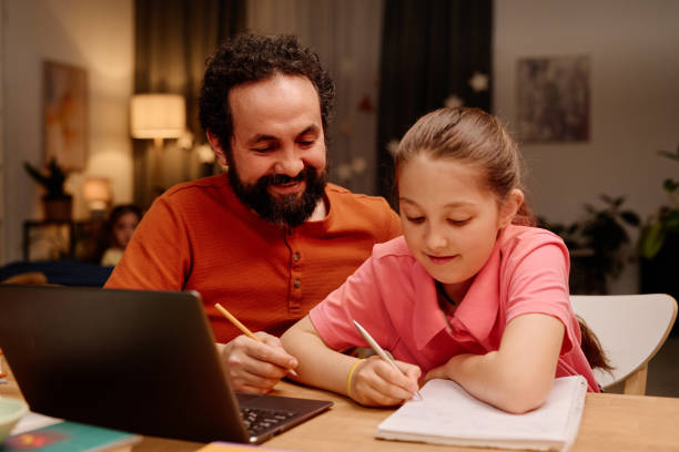 istock Father Helping Daughter with Homework at Home 2168556358