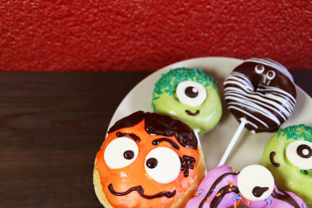 istock Plate of Delectable Assorted Halloween Doughnuts on Black Wooden Background 2168559206