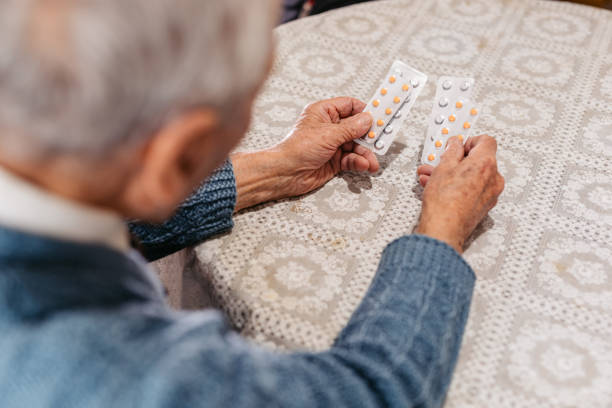 istock Elderly Man Holding Pills In His Hands 2168564445