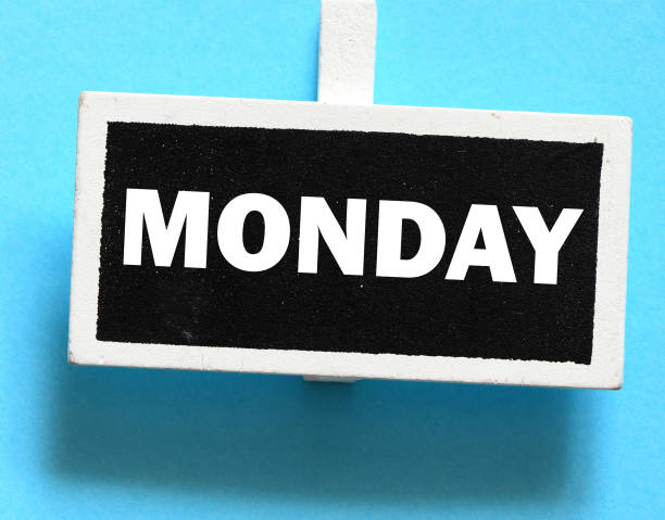 The word MONDAY on a small chalk board over a blue background.