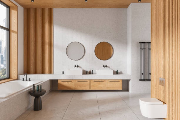 istock Bathroom with two sinks, round mirrors, a bathtub, and wood paneling. Light setting, 3D rendering of contemporary bathroom design 2168579821