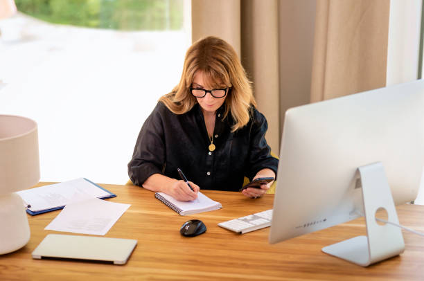 istock Confident businesswoman sitting at desk and using a smarphone and computer for work 2168580624
