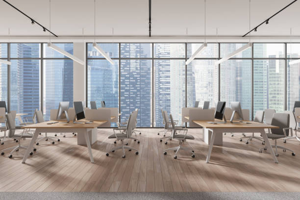 istock Modern open-plan office with computers on wooden desks, overlooking a cityscape, light. Concept of workspace.  3D Rendering 2168582169