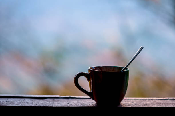 A coffee cup sits on the windowsill in the morning.