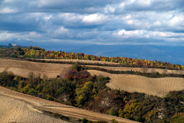 Hilly landscape of plowed fields in autumn against a cloudy sky