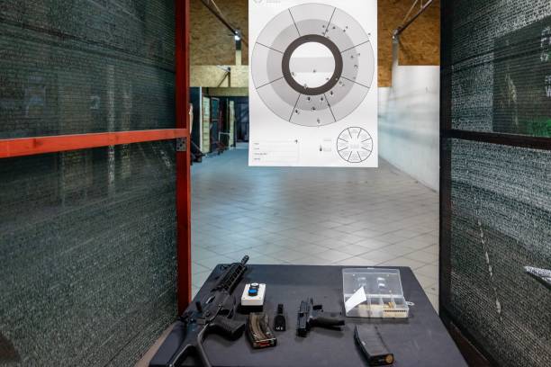 guns, rifle, pistols and bullets laid out on the table at a shooting range