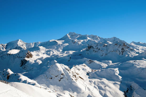 istock Beautiful view of a large snowy mountain range with blue sky 2168586555