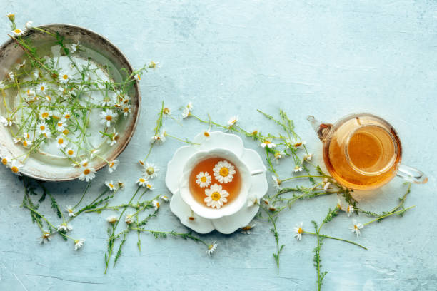 istock Chamomile flower tea. A tea cup and a tea pot with fresh medicinal flowers 2168586815