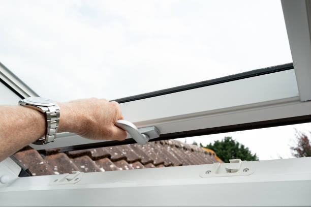 istock Home owner seen pulling shut a newly installed skylight window of a first floor loft conversion for a bedroom. 2168591330