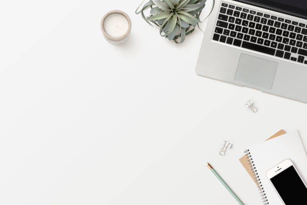 stylish modern minimalist workspace with laptop computer, white smartphone, office supplies, candle and an air plant (tillandsia) - flat lay / top view