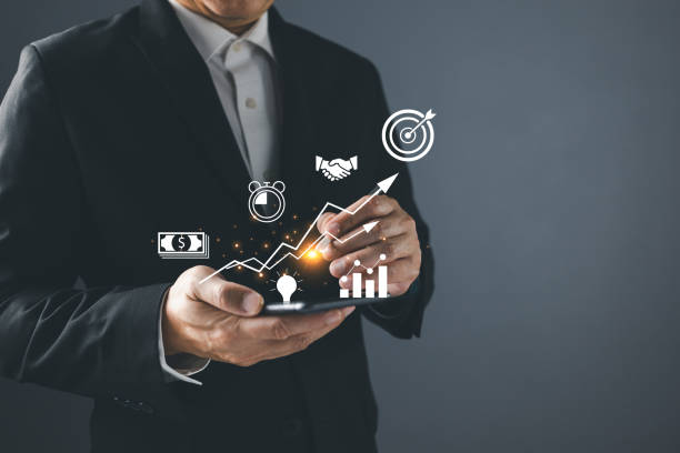 Businessman holding a smartphone with icon business and network connection on modern virtual interface from digital smartphone.Use technology to plan strategy to success goals and growth. e-commerce.