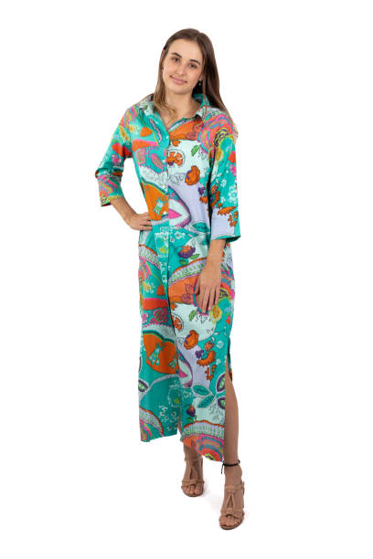 istock A young woman stands in a full-length image, wearing a brightly colored and bold patterned shirt dress against a crisp white background 2168595278
