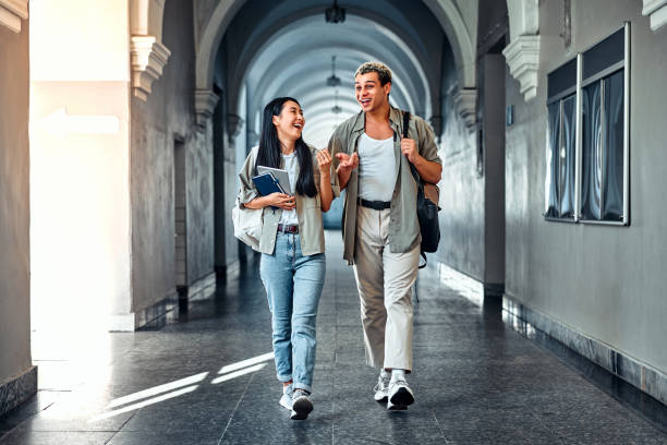 istock Confident smiling beautiful modern friends students go to class in the beautiful corridor of the old university. 2168595708
