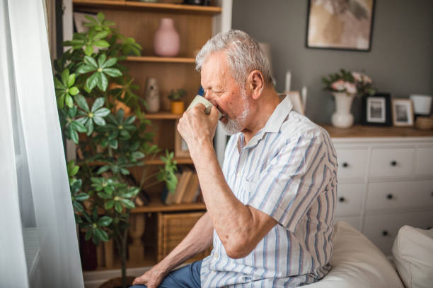 istock A senior man sits on a sofa by the window and drinks his first morning coffee 2168597881