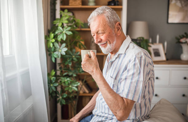 istock A senior retired man sits on a sofa by the window and drinks his first morning coffee 2168597902