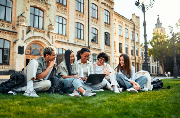 istock College students sitting on the grass on the campus socializing, studying and spending time at leisure. College students. 2168604084