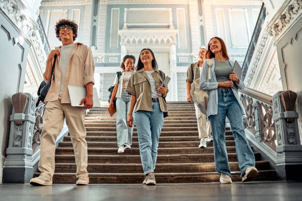 istock Joyful students go down the stairs in the university building and walk forward. Education, bright future and confidence. 2168606933