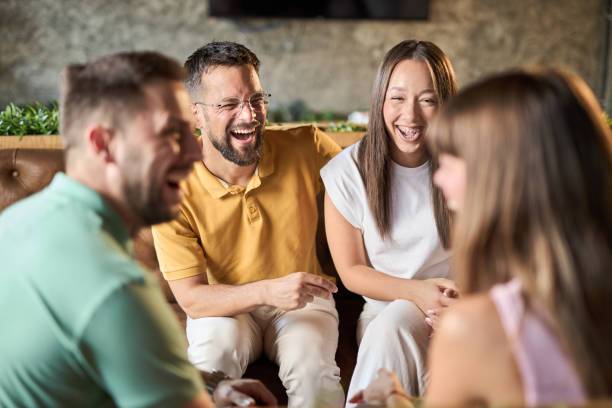 istock Group of happy couples talking while having a social gathering in a cafe 2168607470