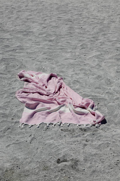 istock A crumpled pink towel on the grey sand. 2168607681