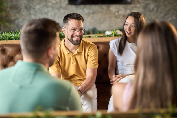 istock Group of happy couples talking while having a social gathering in a cafe 2168607994