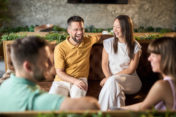 Group of happy couples talking while having a social gathering in a cafe