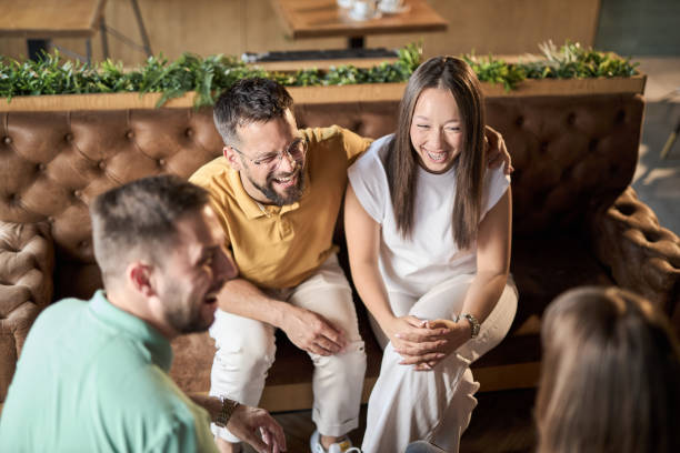 istock Group of happy couples talking while having a social gathering in a cafe 2168608157