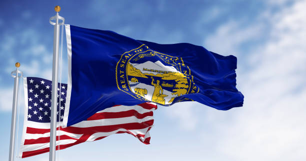istock Nebraska state flag waving with the American flag in background 2168610545