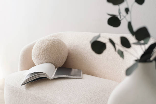 White plush sofa with magazine and plant shadow