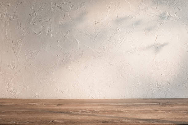 istock Natural light and shadows on textured wall and wooden tabletop. Kitchen background 2168616070