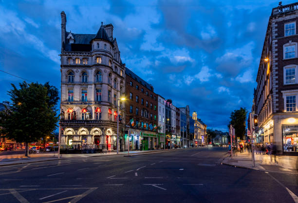 Dublin, Ireland - June 8, 2024: Tourist shops and a wax museum line Westmoreland Street in Dublin, Ireland at dusk.