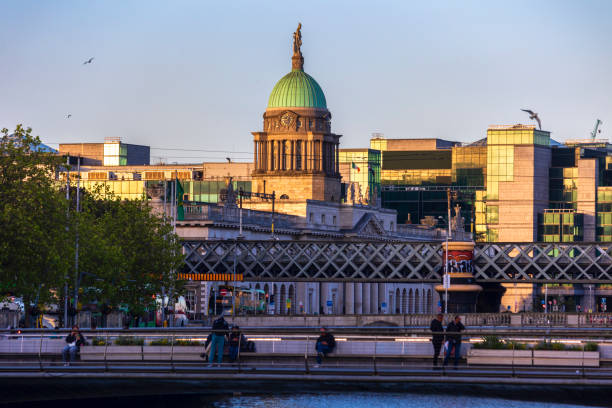 Dublin, Ireland - June 8, 2024: The Dublin Custom House catches the setting sun, behind the Rosie Hackett Bridge and Loopline Bridge. Dublin, Ireland