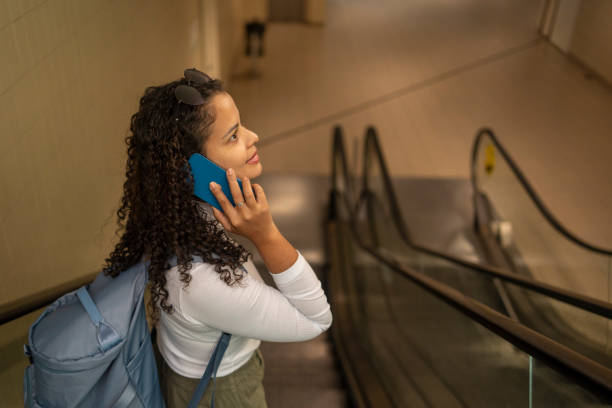 istock Woman with cell phone at train station 2168619704