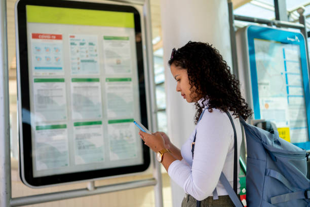istock Woman at train station looking at information board 2168619838