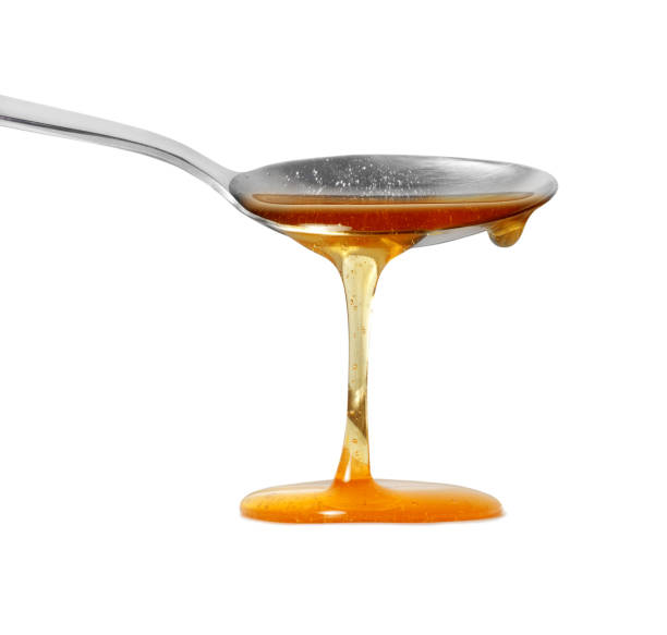 istock Honey flows from a spoon close up isolated on a white background 2168624001