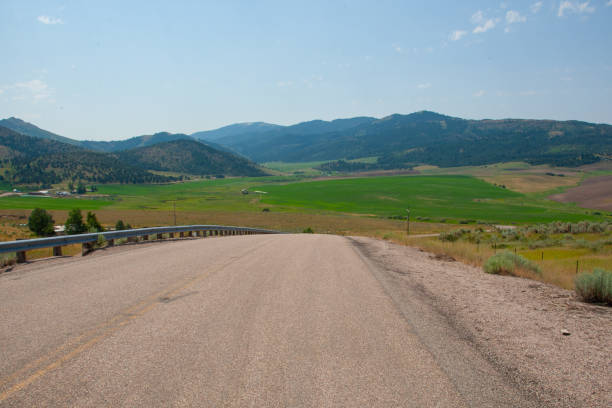 Idaho's lush, rolling green hills create a stunning backdrop, with US-30 winding gracefully through the foreground, offering a picturesque view of the scenic landscape.