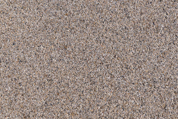 Much little stones on the sand near the water. Walking on the sea beach.