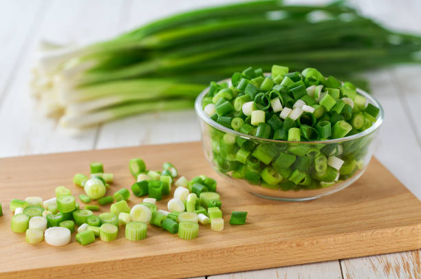istock Chopped scallions or young spring onion in a clear glass , on a kitchen table. 2168630678