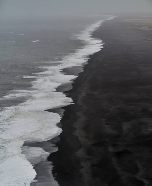istock Ocean waves crashing on black sand beach in iceland 2168636510