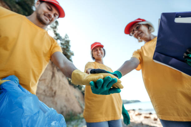 istock Volunteers celebrating successful day after cleaning a a beach 2168637979