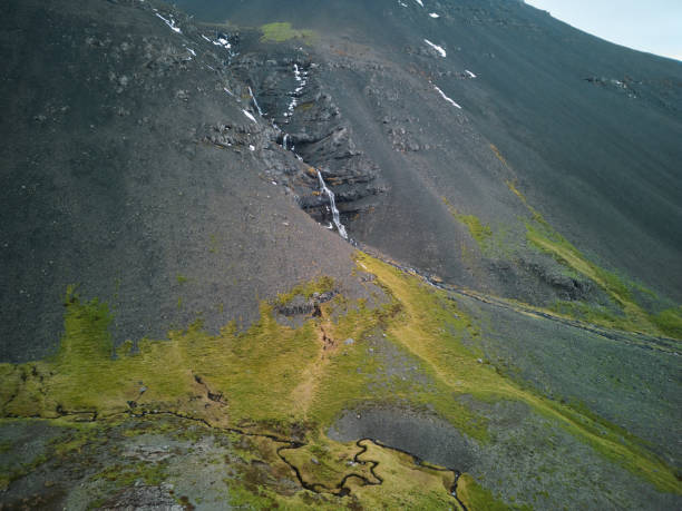 istock Small waterfall cascading down mountainside in volcanic landscape 2168638372