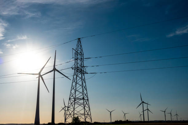 istock Wind turbines and high voltage electric pylon against blue sky. 2168640604