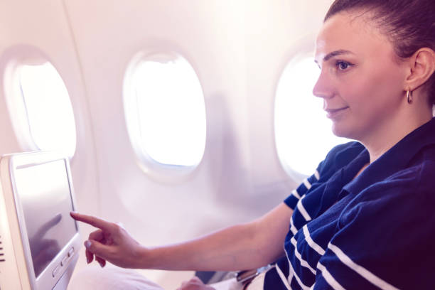 istock Young woman on airplane using on board entertainment 2168644108