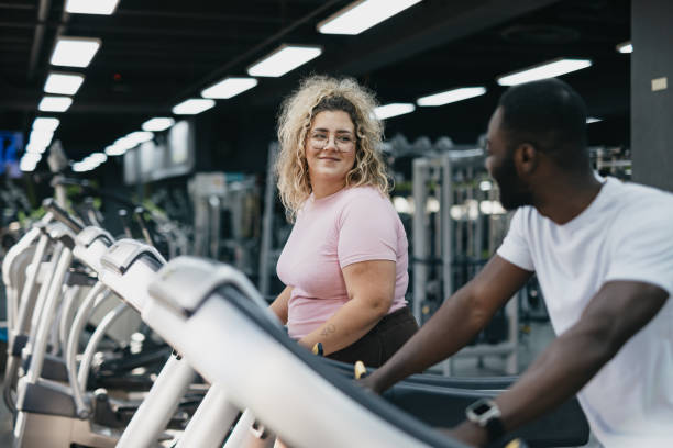 istock Man and woman exchanging smiles during treadmill exercise. 2168645263