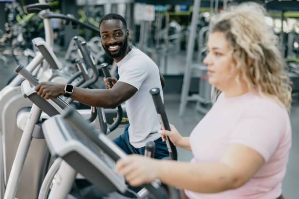 istock Trainer and woman working out on ellipticals, smiling. 2168645514
