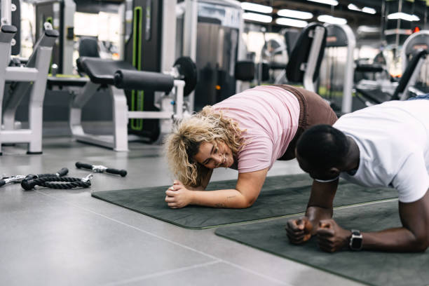 istock Two people doing plank exercise on mats in a gym. 2168645821
